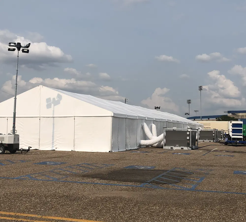 View of the backside of a tent with air conditioner and tubes